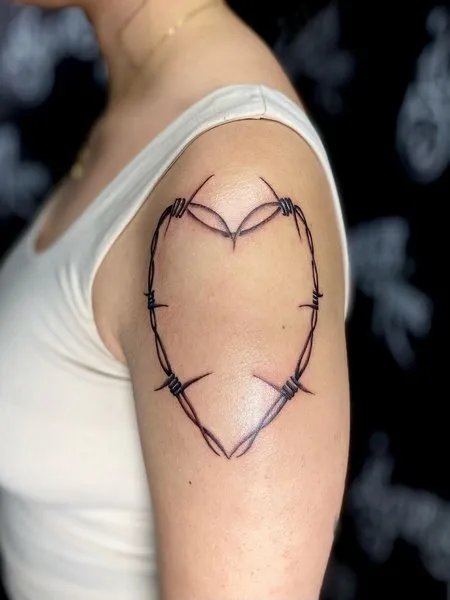 Barbed wire in the shape of a heart inked on the shoulder