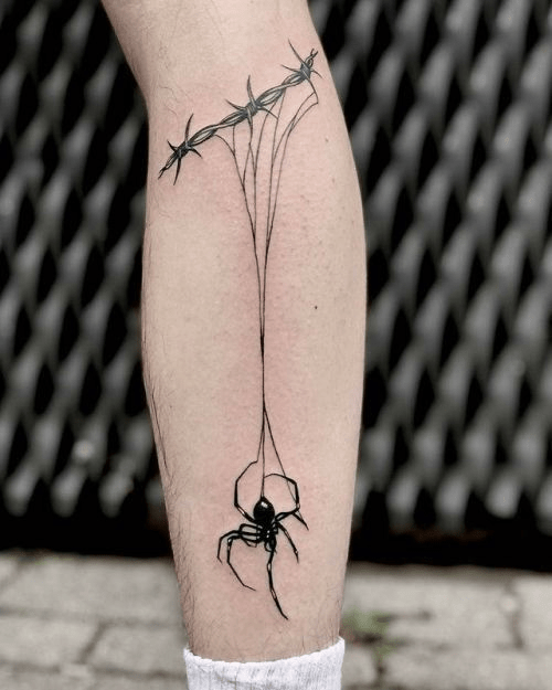 The tattoo of barbed wire and a black spider weaving a web under it