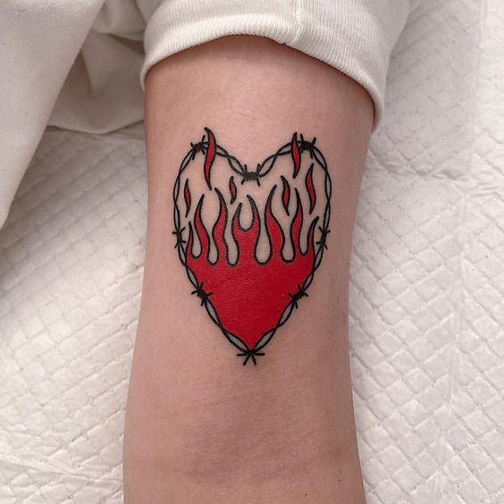 Barbed wire heart tattoo with a red flame inside of it