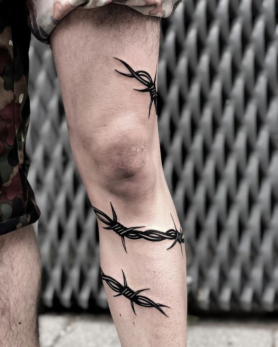 Black barbed wire inked around the leg