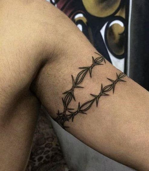 The tattoo of two barbed wires inked on a bicep