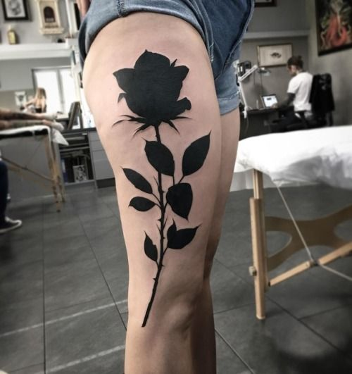 Big black rose tattoo on a thigh