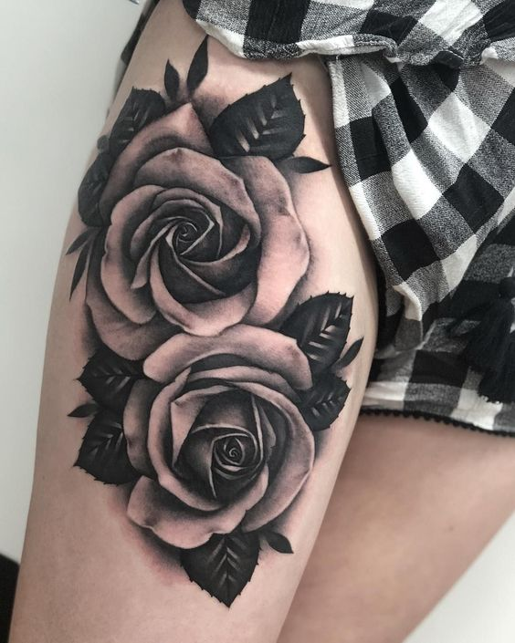 Black rose tattoo on a thigh