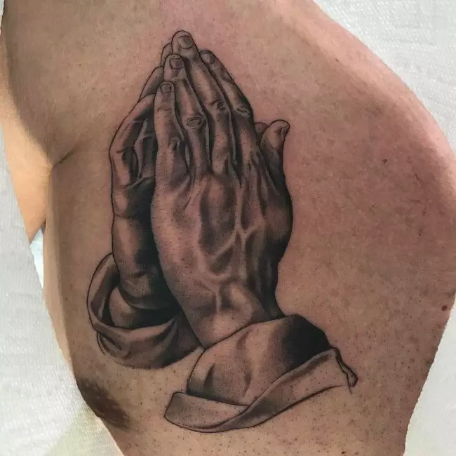 Tattoo with praying hands