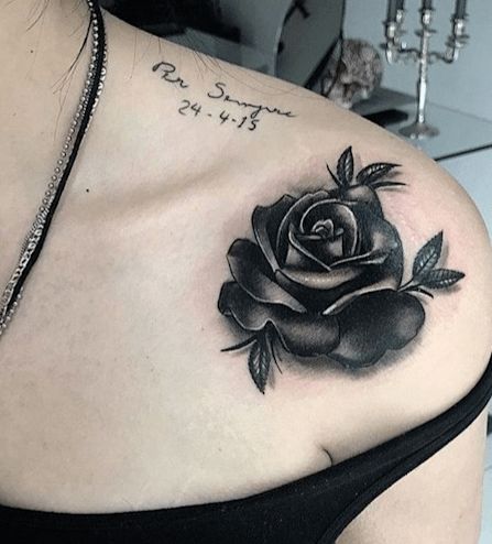 Black rose tattoo on a woman's shoulder