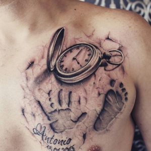 child's hand with birth clock