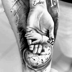 child's hand with birth clock
