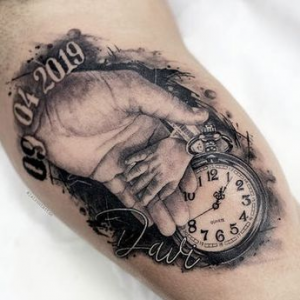 child's hand with birth clock