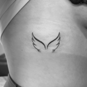 Wings tattoo behind boob
