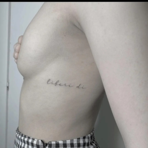 Quote tattoo behind bood