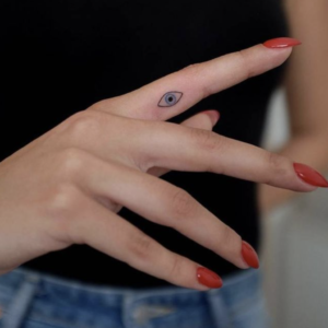 Small finger Evil eye tattoo