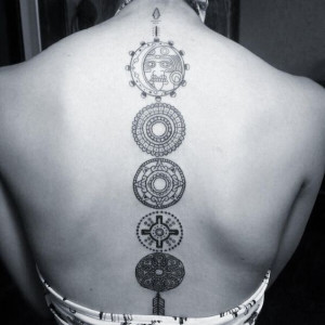 Five circles with Aztec patterns inked on a spine