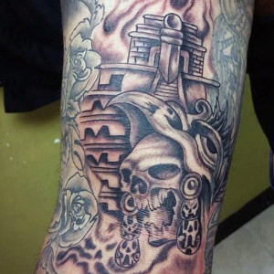Skull and castle tattoo on arm, Aztec-inspired design