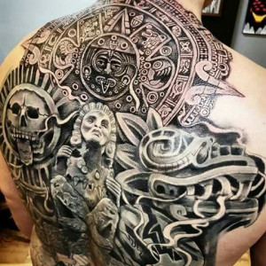 A man with an Aztec-themed back tattoo with a skull and various symbols