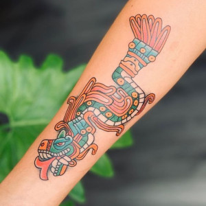Arm tattoo with colorful Aztec dragon design