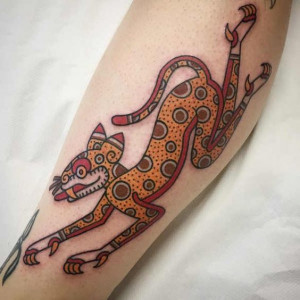 Leg tattoo of a cat design in Aztec style