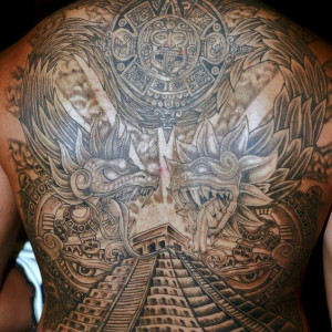 A man with a large Aztec pyramid and dragons inked on his back