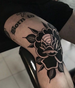Traditional black rose tattoo on the leg