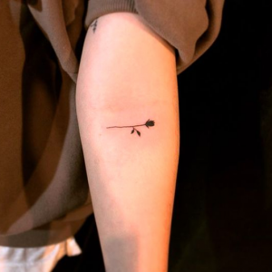 Minimalistic black rose tattoo on the arm
