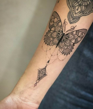 Butterfly mandala tattoo on a forearm