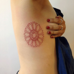 Circle mandala tattoo on the ribs