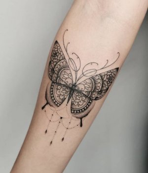 Butterfly mandala tattoo on a forearm