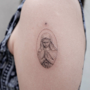 Minimalistic Catholic Mary Tattoo on the shoulder