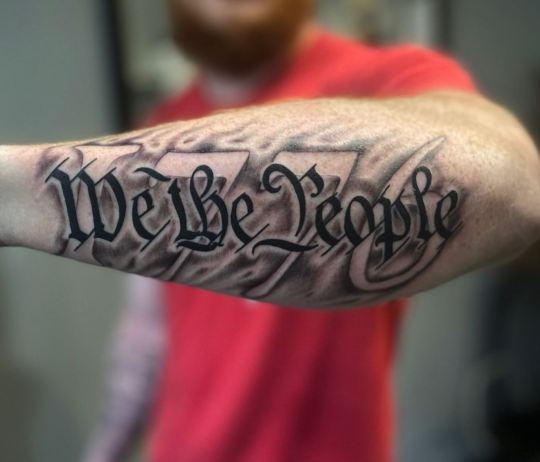 1776 tattoo combined with "We the People", inked on the forearm