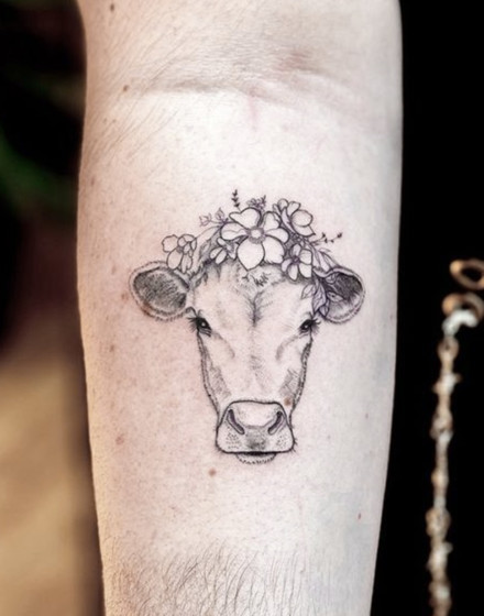 A Cow Tattoo With Flowers