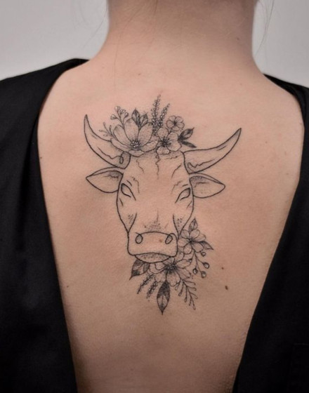 A Cow Tattoo With Flowers