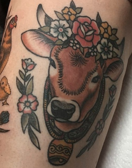 A Cow Tattoo With Flowers