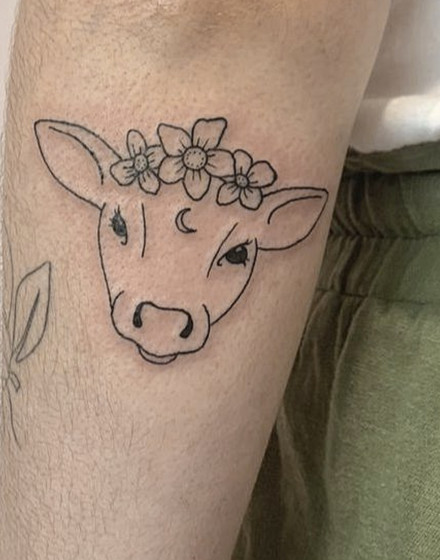 A Cow Tattoo With Flowers