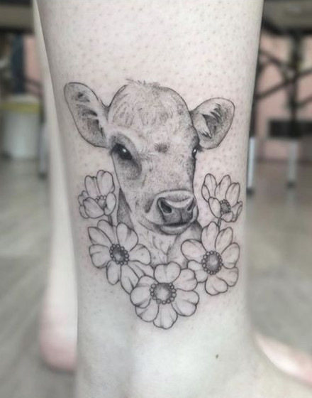 A Cow Tattoo With Flowers