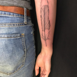 Dove's Feather inked on the forearm in Fineline style