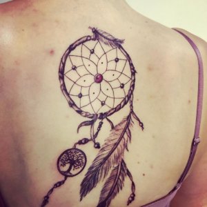The dreamcatcher tattoo with feathers inked on the back