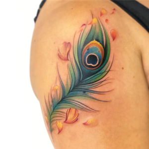 Peacock's feather tattoo on a shoulder