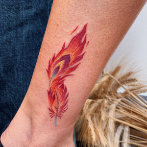 Red and orange phoenix feather tattoo on the arm