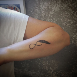 A feather tattoo with an arrow