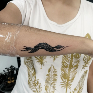 Feather and arrow design inked in black color